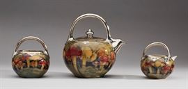 Moorcroft Silver Overlay Claremont Mushroom Teaset  Three piece Claremont William Moorcroft English art pottery porcelain tea set circa 1905. Richly glazed art pottery decorated with mushrooms and silver overlay is marked in green script letters on the underside W. Moorcroft, Shreve & Company, San Francisco, 190. Also marked, RdN2420081. Good condition, aside from one very thin hairline crack on the interior of the sugar bowl that measures approximately 1.25 inches. Otherwise there is no damage, repair or silver overlaid loss. Teapot measures 7.9 inches high x 7.5 inches from spout to back of handle. 