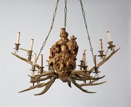 Pair German Leuchterweibchen Mermaid Chandeliers Pair of German 19th century Leuchterweibchen mermaid antler chandeliers. Pair of 19th century or earlier German sixteen light elk antler Black Forest chandeliers. An original image from volume 25 of the 1915 Yale Alumni Weekly show the chandeliers in situ inside the Grill Room at the Yale Club in New York City. The large wood figures of anthropomorphic half woman mermaids holding a crown, coat of arms and goblet, are hand carved. Acanthus detail with fully sculpted body extending into a serpentine scaled mermaid or dolphin tail. Chandeliers suspend from the original three chains. Retains one original brass ceiling cap. The arresting and unusual period lighting fixtures, also include old hard paper gaskets that have an impressed "C" within a diamond, which could possibly indicate J. E.Caldwell & Co. as the installers. Included with the chandeliers are photographs from Volume 25 of the October 1915 - Yale Alumni Weekly showing the Grill Ro
