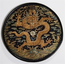  Chinese Imperial Qing Dynasty Round Rank Badge     Chinese Imperial Family Qing Dynasty five-claw gold dragon silk rank badge. The exquisitely embroidered rank badge or dragon insignia roundel, was designed to be worn on a surcoat or robe during the Qing period, 1644-1912. Fine and intricately hand embroidered with gold wrapped thread counted stitch, depicting a gold couched front facing 5-claw dragon on a black silk ground. Fine polychrome silk embroidered clouds, frothy waves, sea motifs and buddhist auspicious symbols. The Chinese embroidered rank badge is from an imperial family member's surcoat or robe. Only men in the extended imperial family through prince of fourth rank were permitted to wear the dragon insignia. No one below the rank of second-degree prince could wear robes depicting dragons with five claws. Embroidery has been protected by being framed under glass. Silk fabric and gold embroidered thread is in good condition. Measures 13 in. diameter including the thin black