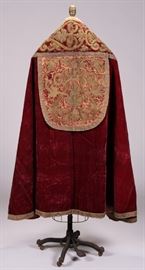 Ecclesiastical French Italian 18C early Textile Vestment  French or Italian Ecclesiastical 18th or early 19th century ceremonial cope vestment cape robe. The elaborate cope is embellished with intricately worked hand stitched ornate gold metal embroidery. The robe is entirely handmade. The ecclesiastical cope was worn by a high ranking papal clergyman. The fine red silk velvet is lavishly embroidered in fine purl goldwork. The high relief gold metal wire thread has been couched down in an intricate pattern of interlaced bands in foliate designs. The raised goldwork decoration appears to be padded and imitates carved fretwork or bands of leather. The intricate raised and skillfully hand stitched needlework is padded gold work onto a velvet ground with a laid work stitch over tiny bundles of gold thread. The embroidered cope hood repeats the lavish raised foliate pattern fit for a high ranking clergyman. The heavy velvet fabric and raised gold metal thread embroidery are surprisingly str