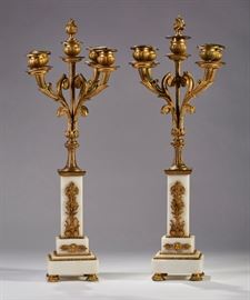  Pair of French 19C Brass Ormolu Marble Candelabra   Pair of 19th century French brass ormolu marble candelabra. The candelabras have white stepped marble supports with ormolu mounts. The five scrolling arms are topped with original bobche and are topped with a flame finial. Measures 19 inches high x 8 inches diameter.