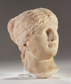 Ancient Early Greco Roman Aphrodite Marble Head      Early carved ancient Greco-Roman marble female head with hair parted and gathered into a chignon at the back of the neck. Appears to be very old may and we believe it to be ancient Greek or Roman. The marble head is heavy in weight. The arrangement of the hair and the soft facial features would suggest that this is the goddess Aphrodite. No base. Good condition, slight wear on tip of nose. Measures 7 inches high x 4.5 inches wide.