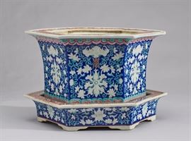 Chinese 19C Porcelain Hexagonal Planter and Tray     Chinese late 19th or early 20th century porcelain hexagonal planter and under tray. Raised embossed blue and white enameling with stylized bat and chrysanthemum decoration. Red meandering pattern on flat rim of each piece. Traces of gilding along the edges, the interior has an orange peel glaze. Measures 7 inches high x 11 inches diameter. In good condition.