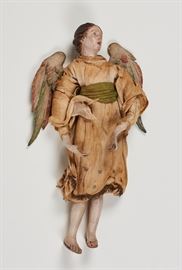 Early Italian Painted Terracotta Angel Creche Figure     Early painted terracotta angel creche figure. The female figure of an angel is dressed in what appears to be the original clothing. Realistically painted with carved wooden polychrome wings. The figure has minor wear and loss of fingertips and small chip on nose. Measures 15.5 inches long x 7 inches across the wings.