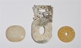 Three Asian Chinese Jade Hardstone Carved Plaques   
Three Old Asian Chinese jade or hardstone carved plaques. The largest is a oval form with hole in the center topped with two dragons, measuring 6 inches high x 3 inches wide. The next is a oval white carving of a bat and fruit, measuring 2.5 inches high x 2.8 inches wide. The third is a soft yellow circular plaque with center hole, measuring 2.4 inches in diameter. All in good condition. Sold together as one lot.