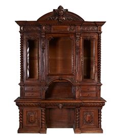 European 19C Walnut Carved 10ft Breakfront Cabinet. European 19th century carved walnut breakfront display cabinet. The cabinet features center drawer has a carved lion's head center drawer pull. Above the arched opening is a gargoyle head and at the top is a Bacchus head on a scrolled support. Shell and swag carving all over with carved and raised panel bottom doors, and raised panels on the sides. In good condition. Measures 116 inches high x 81.5 inches wide x 27.5 inches deep.