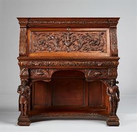 Continental 19C Ornate Carved Gothic Revival Desk  Continental 19th century elaborately carved mahogany Gothic Revival desk. The slant front desk has three drawers on the exterior and three on the interior. The body has all over carving of acanthus leaves and a center urn. It is supported with figures of a philosopher and a knight in three dimensional carving. Good condition with wear from normal use. Measures 45 inches high x 43 inches wide x 20 inches deep.
