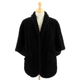 Vintage Persian Lamb Stole: A vintage Persian lamb stole. This satin-lined black stole has a simple fold down collar, two slanted front pockets, and flaps to the front to wrap for warmth. The stole has an original “Pogues Cincinnati” satin tag sewn to interior.