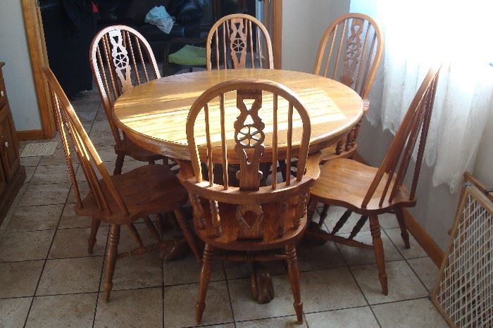 Round oak claw foot table and six oak chairs.