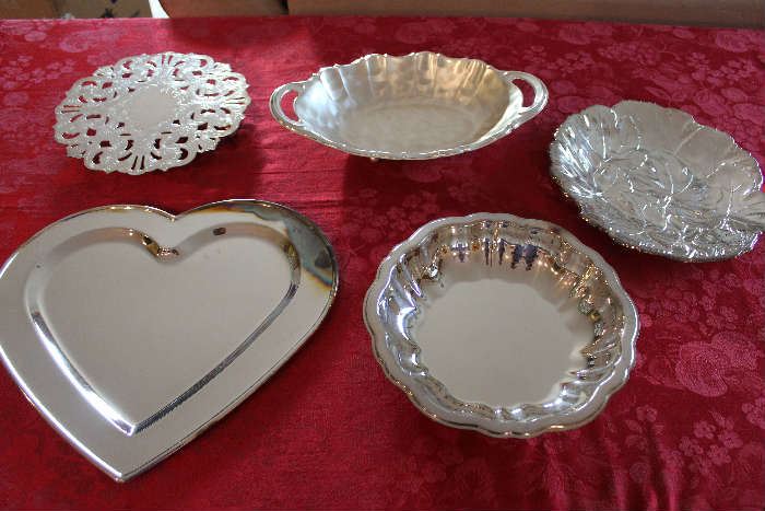 Lot#4 5 Silver-plate Dishes, platters & trivet. Lot includes: 1 silver plate round trivet; Heart Shaped platter; Round silver plate bowl; Ikora Oval Silver plate bowl with handles; Oval leaf patterned silver plate platter by Oneida