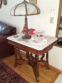 Antique table with marble top. Slag glass lamp