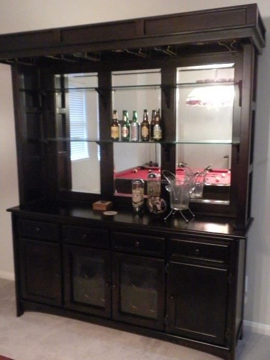 Solid wood bar cabinet dark Cherry finish: recessed lighting in the canopy with brass holders for glassware, Full mirror back w/ 2 glass shelves, 4 drawers, 2 cabinets & 1 double glass door wine storage rack, glass doors are etched and wine storage has a brass light fixture (71"W x 18" L x 84