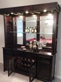 Solid wood bar cabinet dark Cherry finish: recessed lighting in the canopy with brass holders for glassware, Full mirror back w/ 2 glass shelves, 4 drawers, 2 cabinets & 1 double glass door wine storage rack, glass doors are etched and wine storage has a brass light fixture (71"W x 18" L x 84