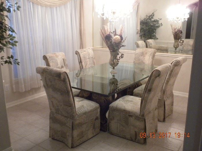 Formal Dining room Table (48"W x 84"L) glass topped 3/4" thick w/ waterfall edges & bumped corners sits on (2 ) fern design bases, (8) Chairs (11" x 23" x 29"H) fully covered & skirted in beautiful fabric.
