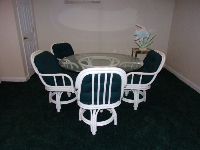 Rattan glass top kitchen/indoor patio table and four swivel seat rattan chairs.