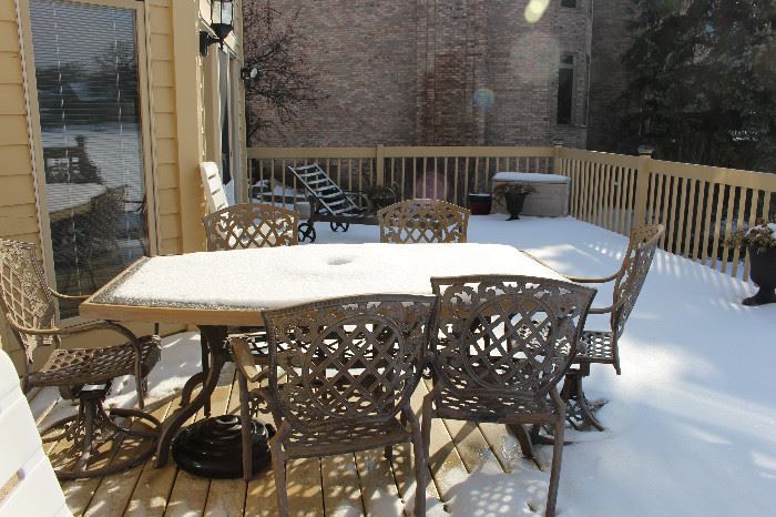 This is a beautiful patio set and in the rear of the photo, a chaise lounger, side table, and more.
