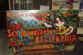 This is a painting on board about 48 by 24 inches, by artist Robert Hanna.  It was created in 2012 for this project (excerpt):  The City of Ventura’s Public Art Program is announcing a call to artists to design and create life-sized “cut-outs” designed for photo opportunities, to be placed at various tourist sites
throughout the City. This is an exciting opportunity limited to Ventura County artists. It is
anticipated that three winning designs will be selected for fabrication. This project has been
designed to meet the following goals:
• To create opportunities for cultural tourists to engage with the work of local artists
• To produce positive, nostalgia-driven interaction between visitors and our destination
(based on the “Experience Economy” model)
• To reinforce Ventura’s brands as “California’s New Art City” and “The Real California”
an arts destination
• To highlight the significance of the locations the cut-outs are placed as tourism sites
• To weave art into the fabric of our 