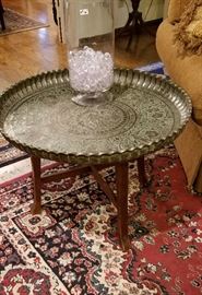 Large brass tray table with wooden stand, picture of one of the larger rugs.