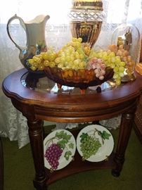 Nice decorative table with glass insert, decorative plates, pitcher, carnival bowl, table lamp, grapes, and more