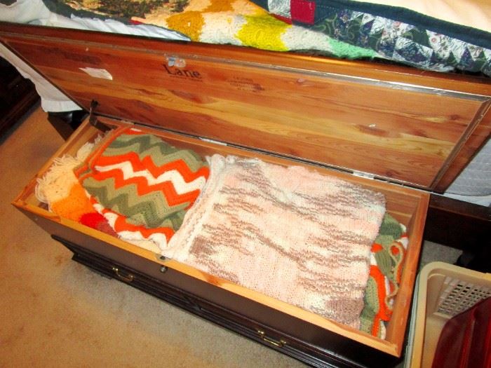 Cedar Hope Chest  by Lane Furniture filled with many hand knitted Afghan throws and blankets