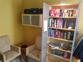 Two tan microfiber armchairs, glass front bookcase and wall shelves may be removed from wall