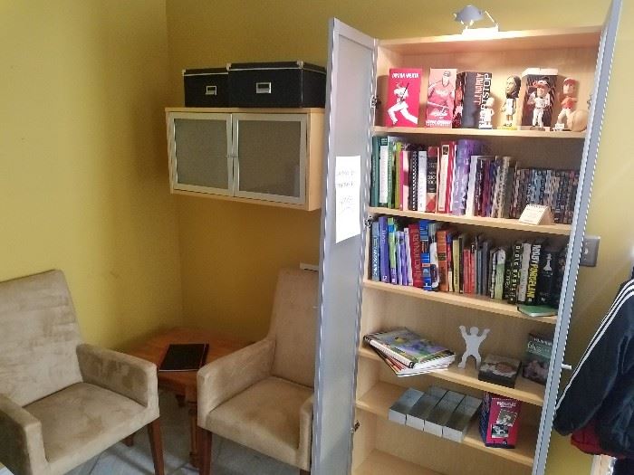 Two tan microfiber armchairs, glass front bookcase and wall shelves may be removed from wall