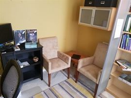 Small black bookshelf, flatscreen monitor, books and sports bobbleheads