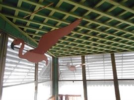 There are several birds hanging from this ceiling on the upper floor porch