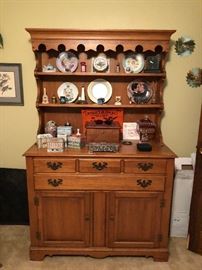 Tel City maple breakfront, collectible tins and plates, wooden storage box, silver plate  jewelry box, cranberry glass covered candy dish, trivets