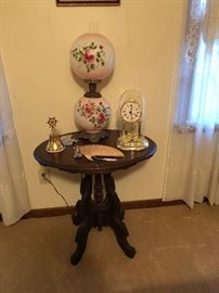 antique victorian oval table, gone with the wind lamp, clock, brass bell, oriental fan
