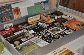 Costume vintage jewelry including Eisenberg Coro Sperry Trifari Bergere Napier Monet Kramer and more, Cross gold-filled pen in case, Cross gold-filled pen with red stone, Dunhill service lighter in box, eyeglasses vintage, flag pennants prison souvenir vintage, Greater Bellevue Washington brochure/booklet 1965, Jiu Jitsu 1940s booklet, Josephson & Sharp Sharpo lighter, Majestic fountain pen 14k nib, Maxim Mercury Les Briquets lighter new in case, men's cufflinks tie pins tie clasps, Navajo sterling belt buckles, pin back buttons, postcards vintage, straight edge razor celluloid handle Hitchcock in case, straight edge razor celluloid handle Wilbert in case, U.S. Mail miniature canvas bag with 8 souvenir photos, Zippo lighter. MORE items will be added to the case prior to the sale!