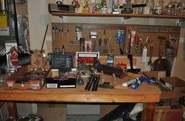 Large work bench, miscellaneous tools, ice chests and coolers, luggage, saws, florist vases, some lumber, chains, and more