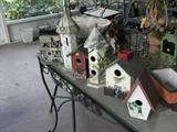 SOME OF MANY BIRDHOUSES ON WROUGHT IRON TABLE W/CHAIRS