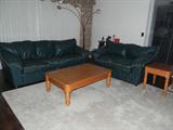 LEATHER SOFABED AND LOVESEAT W/ ACCENT PIPING. SET OF TABLES AND OVERHEAD LAMP.