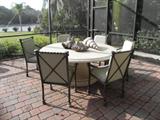 STONE TABLE W/ SIX CAST IRON CHAIRS