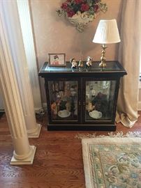 Oriental cabinet with many collectible figurines.  Notice the oriental, room sized rug on the floor.