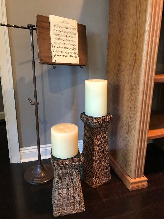 Antique music stand and rattan candle holders with candles.