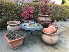 Largest pots (with plants) are weather resistant and can be left outside during the winter. Other pots are terra cotta.  