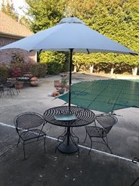 Bistro set with umbrella and iron stands. There are several patio umbrellas to pick from!