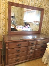 Bedroom set is solid maple. Beautiful. These pieces are covered with glass.