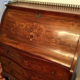 Detail of Serpentine front drop front inlaid desk.