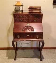 Drop-front highly carved ball and claw foot desk.