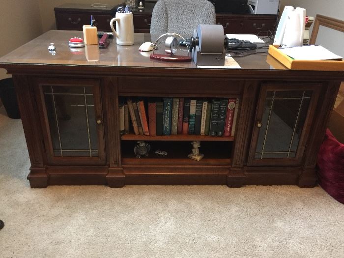 BUY IT NOW!  Lot #101 - Beautiful Executive Desk.  Two cabinets in front with leaded glass doors & glass shelves.  Desk has a thick glass top to protect the herringbone pattern design.  It has seven felt-lined drawers.  Dimensions 70" x 34" x 30" (high) - $750