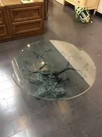 Glass top coffee table with metal branch and frog base