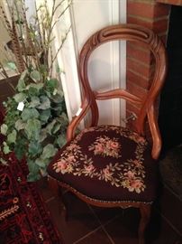 Antique chair with needlepoint seat; artificial plant
