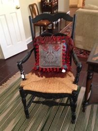 One of a pair of black wood rush seat chairs; "Gipson Girl" pillow