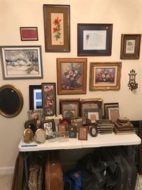 Many framed items and frames for family photos.