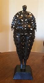 Metal female sculpture in an open weave with a dark brown distressed textured finish, on a square black base