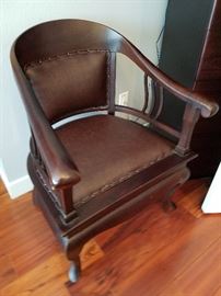 Solid wood and leather arm chair.  No maker.  Barrel arms with rivets.  33" tall, 25" wide at arms.