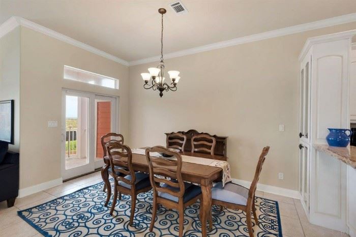 DINING TABLE WHICH HAS A LEAF AVAILABLE, 2 ARMCHAIRS, AND 6 SIDE CHAIRS WITH CUSTOM UPHOLSTERY.  FUN RUG IN THIS SPACE